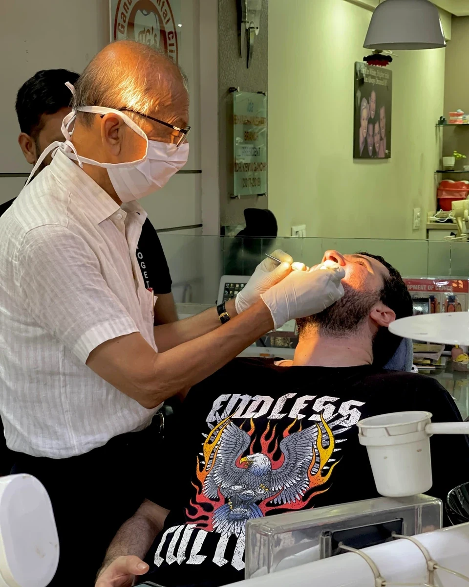 Experienced dentist examining a patient at Gandhi Dental Clinic