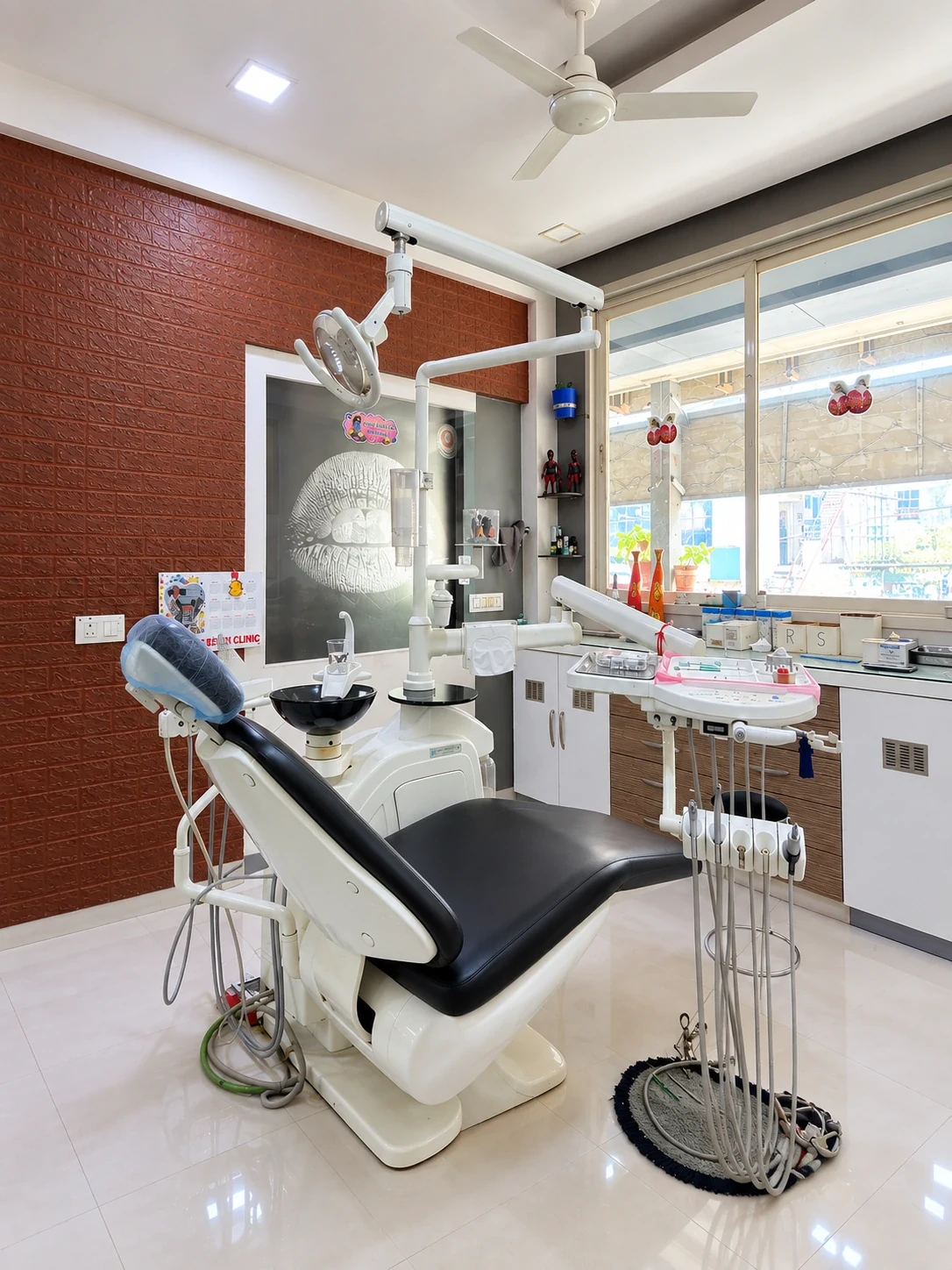 Black dental treatment chair beside a bright clinic window