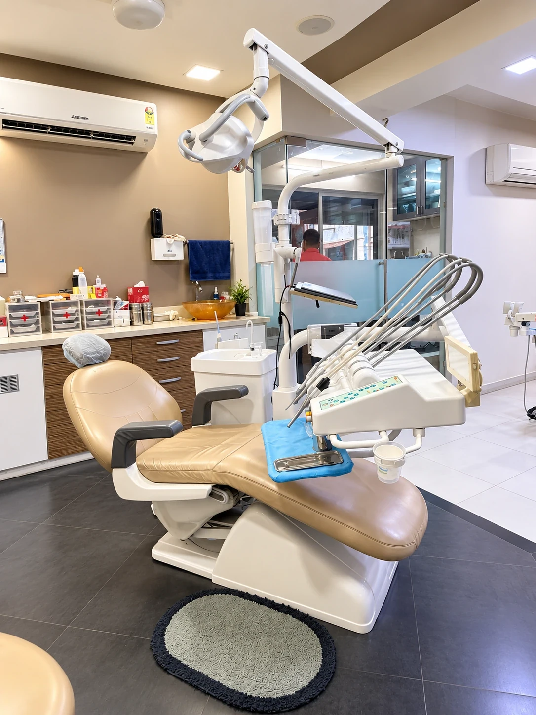Beige dental treatment chair in a fully equipped clinical room